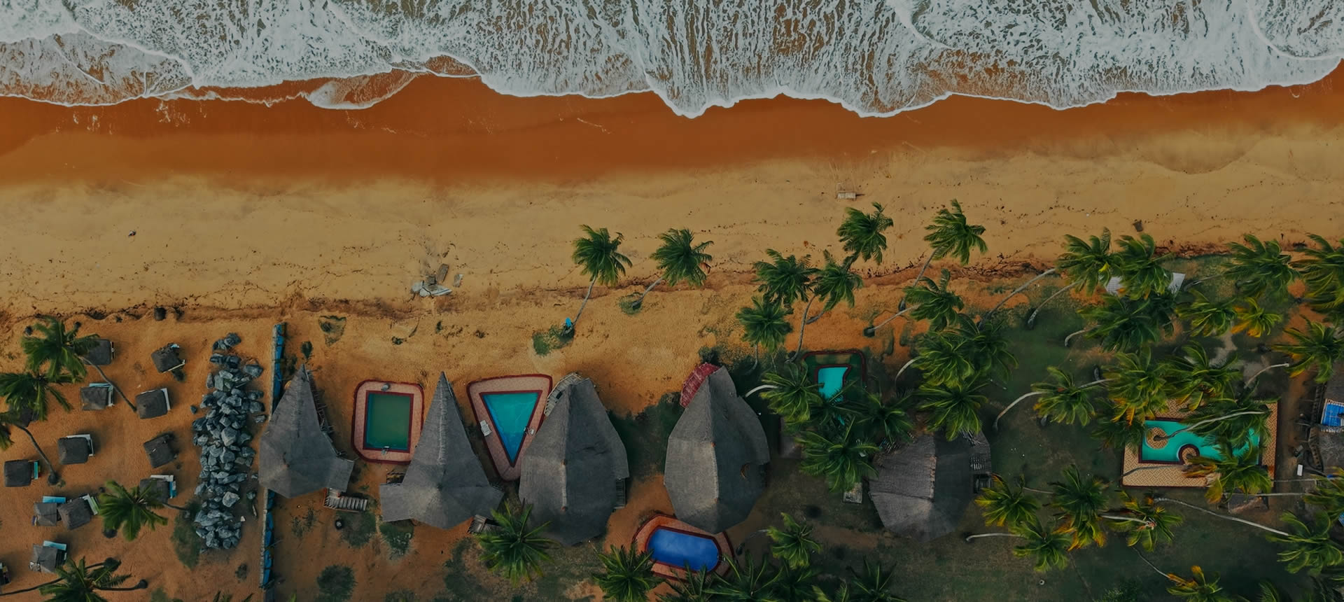 Aerial view of a coastal resort, palms and beach used as getaway inspiration
